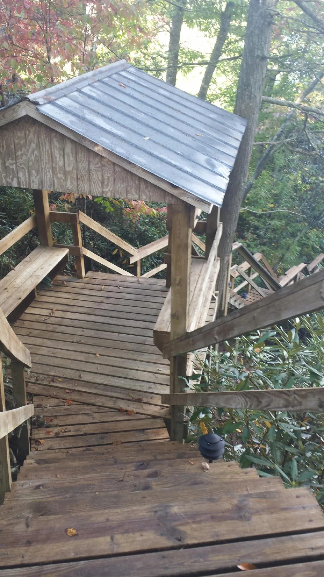 Metal roofed shelter over wooden steps on a wooded walkway — Skylight Repair & Installation work by our crew in French Lick
