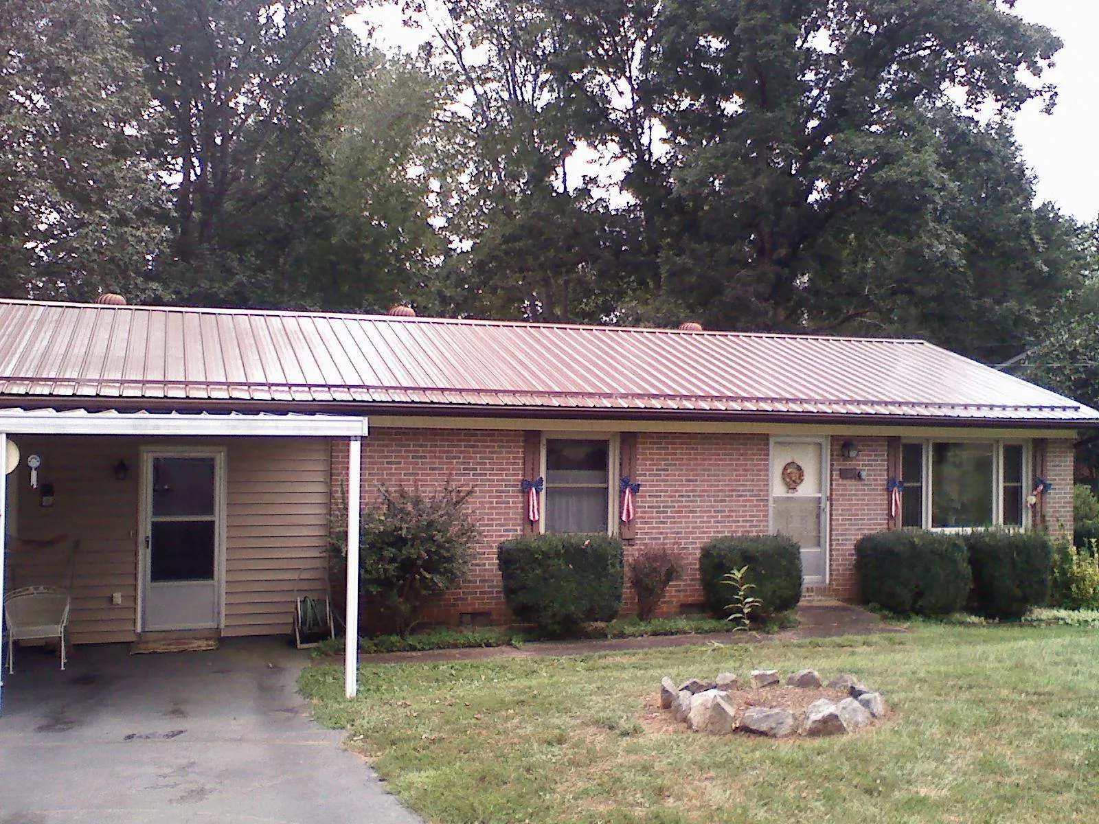 Bronze metal roof and carport on a brick ranch home — Roof Repair work by our crew in French Lick
